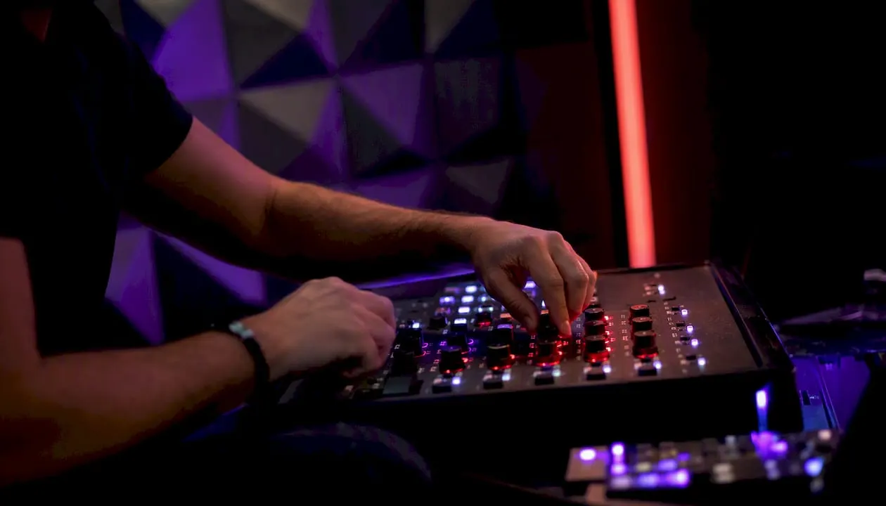 Hands tuning trading controls in dark studio