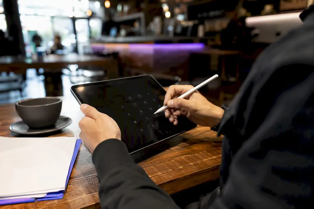 Hands calculating forex trade pips on tablet
